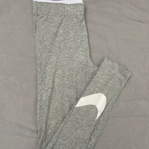 Nike tights - Gråa tights från Nike men en logga runt smalbenet. Ej i träningsmaterial. Mycket bra skick. Köparen står för frakt.