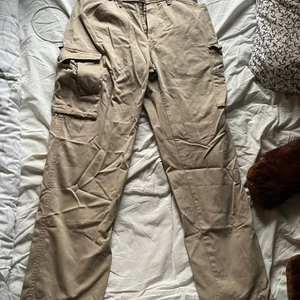 Cargo byxor - Beiga kargobyxor med stora fickor på båda lår. Storlek står ej men skulle gissa på storlek 40, 41 eller 42 kanske. Om du har några frågor så är det bara att kontakta! :)