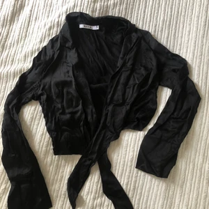 Svart siden Festtopp  - Svart festtopp från NAKD i satin material strlk XS-S. 