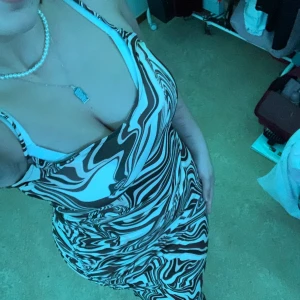 En brunrandig klänning  - Jag säljer den här brunrandiga klänningen från Bershka som är super elegant till en fest, lång och ett slits up i högra benet där man kan knyta 🤎