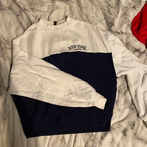 Blå/vit tröja - Blå/vit tröja från HM i stl S med ett tryck strax över vänstra bröstet där det står ”NEW YORK” och under ”St. MarksPlace”