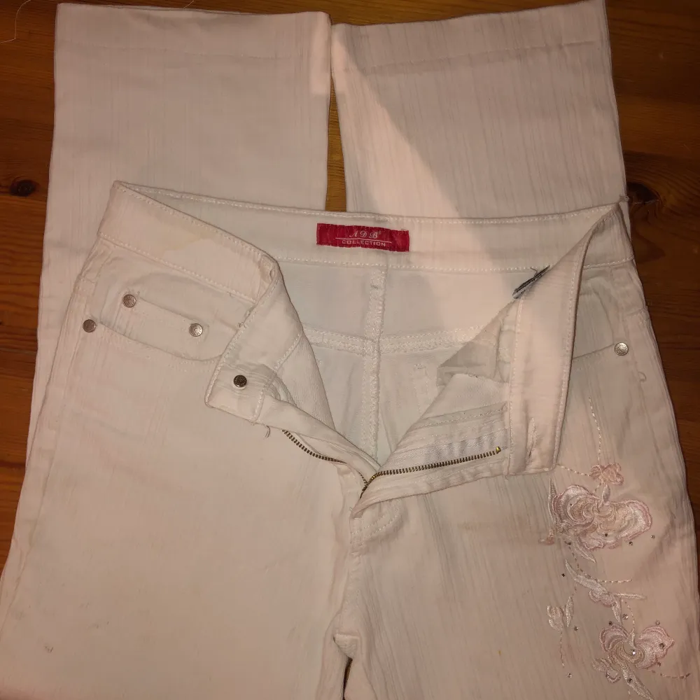 Vita ”ribbade” byxor med broderade blommor. Storlek S/M.. Jeans & Byxor.