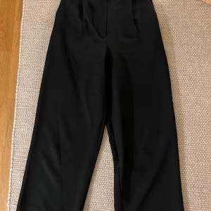 Svarta kostymbyxor från nakd i storlek xs/s med resår i midjan bak
