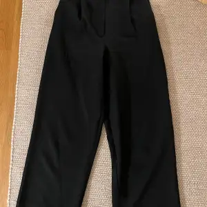 Svarta kostymbyxor från nakd i storlek xs/s med resår i midjan bak