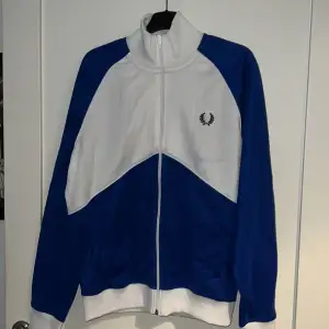 Fred Perry track jacket. Condition 6/10. Small blue stain from washing jacket. 