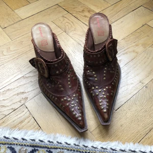 Cowboy mules  - Cowboy mules! Är speechless😍 dessa är i 100% skinn och toppenskick från märket Nana. Underbar färg med nitar och spänne fram på skon och träklack bak☺️strl 39! Men funkar för 38,5 också (eller 38 med strumpor i, annars sann 39). Skriv för fler bilder!🤠