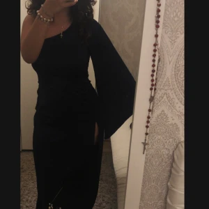 Enärmad klänning - Aldrig kommit till användning, därav säljer jag :) Den är marinblå och är i storlek M/L. Har en ärm med flare och en slits vid samma sida. Ger en hourglas form o väldigt fin till bal eller liknande 💞