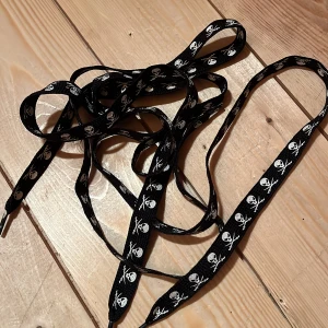 Skosnören - Två skosnören med döskallar 