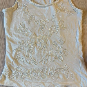 Unikt nine lives topp vintage  - Vintage nine lives topp i paljettdesign med en katt och blommor på. Supersnyggt på! 