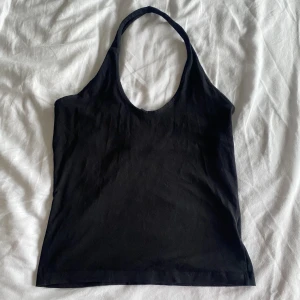 halterneck topp - halterneck topp i färgen svart. är öppen på ryggen. storleken är 36-38. köparen står för frakt 