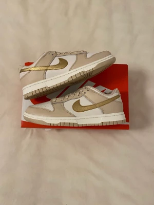 Nike Dunk Low (W) ”Metallic Gold” - Hej! Jag säljer några helt nya par Nike Dunk Low ”Metallic Gold” i storlek 37,5 för 1700kr st ink frakt! 💫  Fraktar samma eller dagen efter betalning frakt 🚚  Bara att skriva vid frågor💖