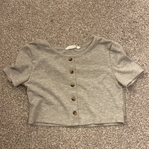 Grå topp - Säljer denna gråa, ribbade toppen från SHEIN i storlek 134. Den är använd en del gånger men är som ny, jättebra skick. Jag säljer den för 10kr❤️