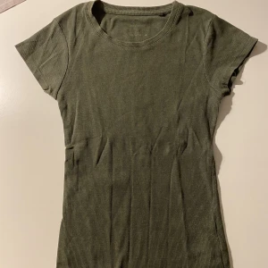 T-shirt camogrön (strl. M) - En vanlig t-shirt köpt på NewYorker. Väl använd och är perfekt på sommar. Nypris ca 150kr. Ok-skick. Priset kan diskuteras!