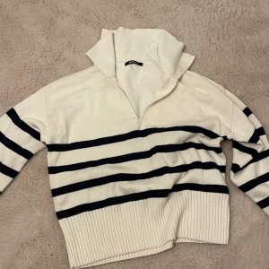 Stickad tröja med krage - En stickad tröja med krage från Gina tricot, i strl s . Rätt så kort i modellen men bred. Kontaktas privat för andra frågor👍  ( ränderna ser svarta ut på bilden , men är igentligen väldigt mörkt blåa ) 80kr + frakt , oanvänd.