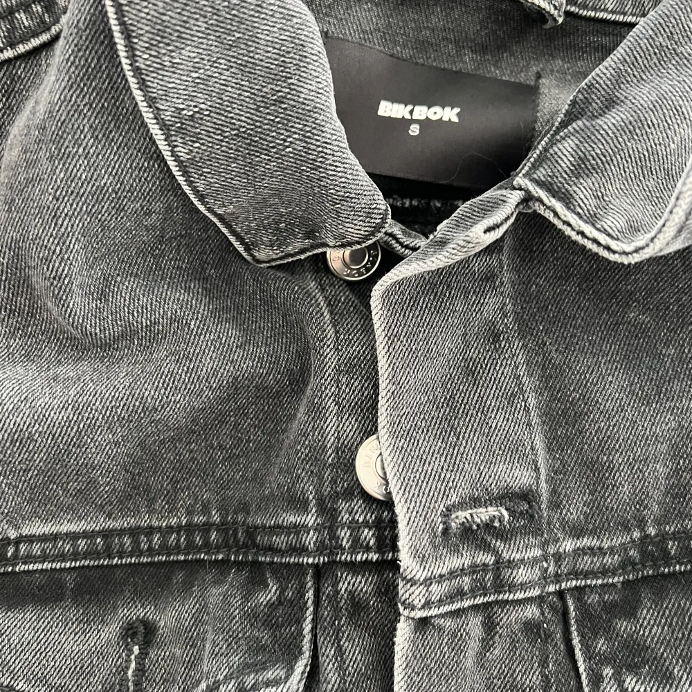 En grå/svart jeansjacka från Bikbok. Använd fåtal gånger! Är i storlek S! Köparen står för frakten. Jackor.
