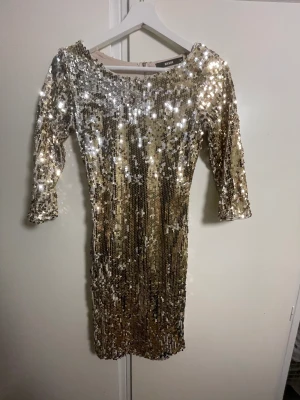 Klänning  - Glitter klänning med öppen rygg. Kurvsydd 