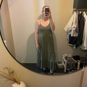 Grön långklänning med tunna axelband. Jag är 182cm och klänningen går ända ner till fötterna.