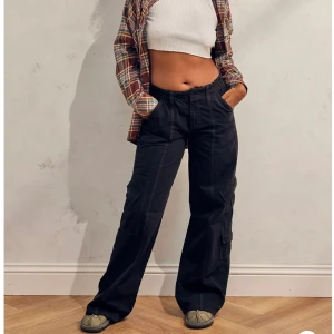 Low rise cargo pants - Ett par helt nya, aldrig använda low rise cargo pants från Urban Outfitters. Storlek M längd 34. Originalpris 750kr, säljer för 500 + frakt :)