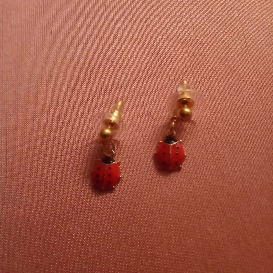 Guldfärgade örhängen med hänge av en Nyckelpiga 🐞 .