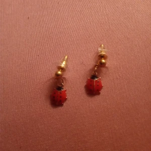 Guldfärgade örhängen med hänge av en Nyckelpiga 🐞 . - Fina små Guldfärgade knoppar med hänge av en Nyckelpiga .ej Guld .nickelfritt .Egen design .hämtas alt skickas .portofritt 