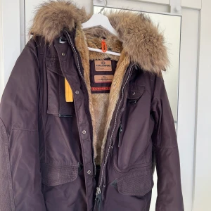 Parajumper jacka - Säljer denna bruna para jumper jackan. Den är i nyskick, bara använd några fåtal gånger. Den har gula detaljer både fram och bak. Nypris av jackan är 9500kr men jag säljer den för 4500kr.