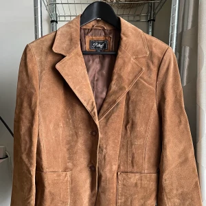 Vintage jacka - Köpt second hand! Har en mocka aktig typ av material. Har en innerficka. Står att den är strl 44 men skulle uppskatta den till en M mer.  Använd endast en gång 🍁