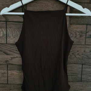 Brun body - Brun body från H&M med lågt skuren rygg. Stringmodell med knäppning.