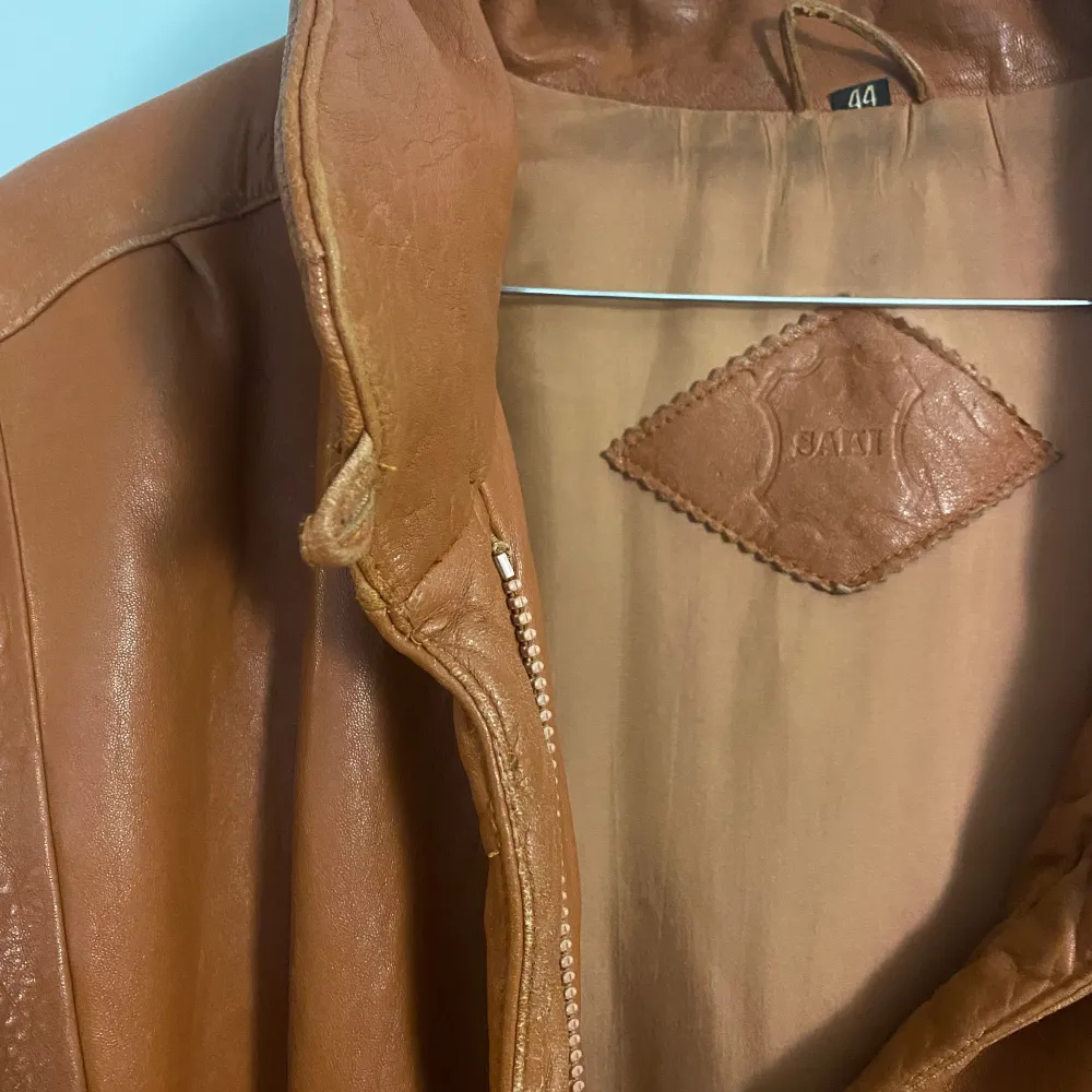 Brun superfin vintage läderjacka med detaljer på fickor, ärmar och en liten öppning i sidan. Väldigt unik! . Takit.