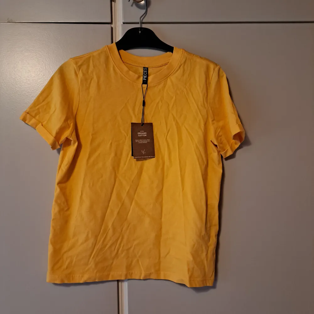 Säljer denna härliga somriga och gula tshirt från Zalando med märket Pieces för 40kr (ursprungspris 150 kr). Storleken är XS.  Den går ej att köpa. Prislapparna kvar.  . T-shirts.