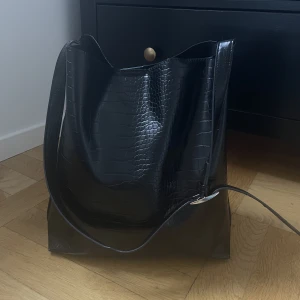 Axelremsväska i ormskinnsimitation - Så fin väska från Carin Wester som tyvärr inte kommer till användning längre. Fint skick bortsett från några mindre defekter som jag kan skicka bild på, men inget som syns! Väldigt rymlig och har även ett litet fack inuti samt en magnetisk knapp 💜💕