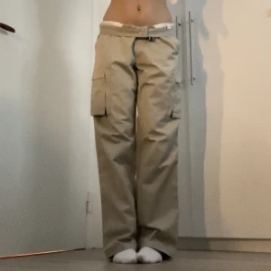 Dunderdon baggy cargobyxor - Beigea baggy cargobyxor från märket dunderdon. Stor storlek med en stor midja så jag har haft dom med ett skärp eller vikt ner dom som på bilderna. Jag är 170 lång. Älskar dom här byxorna så säljer bara för ett riktigt bra pris. Köparen står för frakten.
