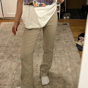 Beiga chinos/kostymbyxor - Säljer mina perfekta chinos/kostymbyxor i en fin beige färg som passar till typ ALLT! Går utmärkt att vika upp dem i benen om man är typ 160 som jag! Diskreta dragkedjor längst ner på vardera ben. Skriv för blir bilder/exakta mått!💌Storlek 24-26 ish