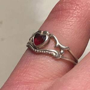 En super vacker ring med fin röd sten i form av ett hjärta i äkta silver (se sista bilden för stämpeln). ❤️