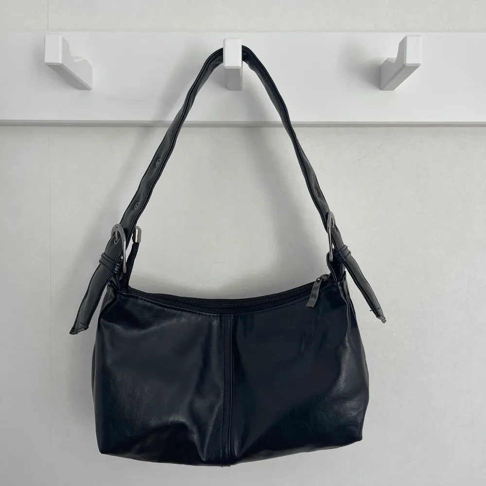 En svart väska i skinn som är vintage och justerbar i banden. Hör av dig vid frågor 😗. Väskor.