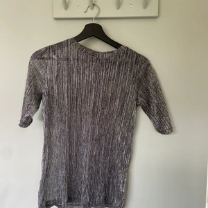 Festtopp - Glittrig festtopp som är något genomskinlig. 