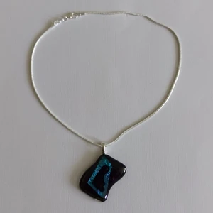 Egen designat halsband med dicroglashänge - Halsbandet är 42cm, ett ovanligt, det finns bara den Hänget är 4×3cm, det syns inte på bilden men bakgrunden är mörklila och botten är svart, kan byta till ett längre halskedja  Nickelfritt förstås  Skickar med postnord ett frimärke 13kr