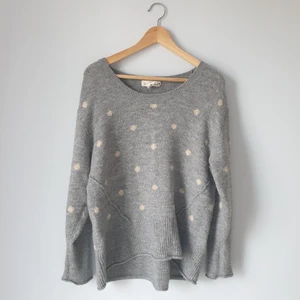 Grå stickad tröja - En grå stickad tröja med vitrosa prickar. Köpt på H&M. Storlek L 62% akryl, 28% polyamid, 8% ull och 2% elastan.