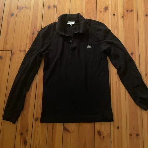 Lacoste Pike - Svart långärmad Lacoste pike skin fit FR2 i strl XS Nästan aldrig använd 