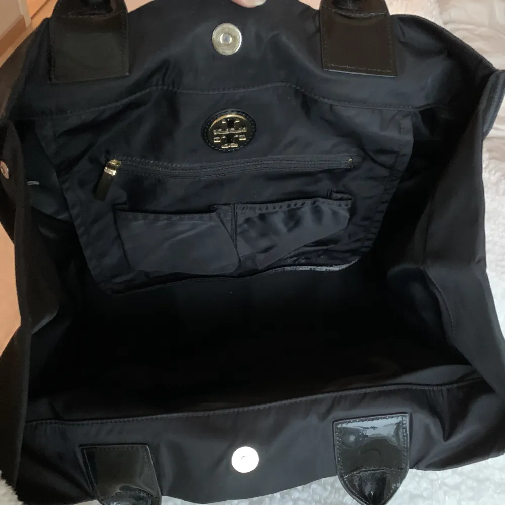 Svart Tory burch shopper/tote väska i nylon och läderdetaljer.  längd:42 bredd:17cm höjd:30 Nypris ca 3000kr. Väskor.