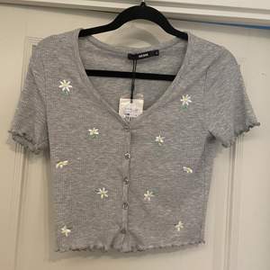 Jättesöt t-shirt med broderade blommor på från bikbok. Aldrig använd, prislapp kvar. Säljer då den aldrig kommer till användning. Köpt för 199kr. Storlek S, normal i storleken.