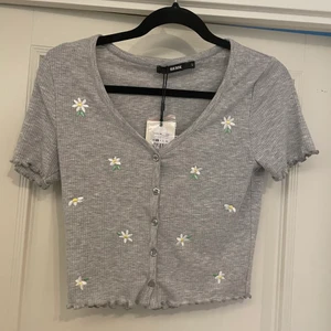 Tröja - Jättesöt t-shirt med broderade blommor på från bikbok. Aldrig använd, prislapp kvar. Säljer då den aldrig kommer till användning. Köpt för 199kr. Storlek S, normal i storleken.