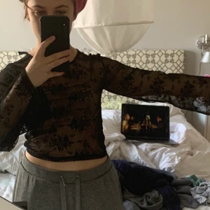 Spetstopp i svart - En supersnygg spetstopp i svart med blommor som jag säljer på grund av att den är för liten! Den är kort och har vida ärmar. Skickar eller möts, men då står köparen för frakten