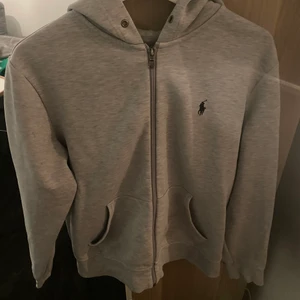 Ralph Lauren zip hoodie - Säljer en grå Ralph Lauren zip hoodie i storlek herr M. Den är i fint skick och inga skador. 