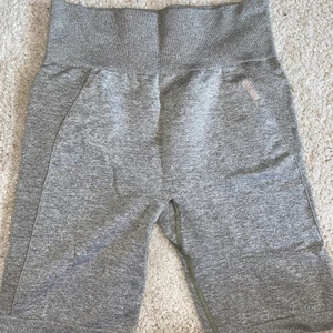 Gymshark flex bike shorts M - Ett par cykelbyxor från Gymshark i modellen flex. De är i en grön/grå färg med rosa text bak. Sitter superbra och är i gott skick! De är i storlek M men lappen är borttagen.