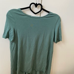 T-shirt från Cos - Fin T-shirt från Cos i härlig grönblå färg. Storlek 34. Skön modell som är loose och lite längre baktill. Fint skick utan anmärkningar.