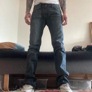 Levis 506 osäker över storlek pga lappen är borta men sitter som 32/34. Slim fit med lite flair. Sömmen vid ankeln är öppen