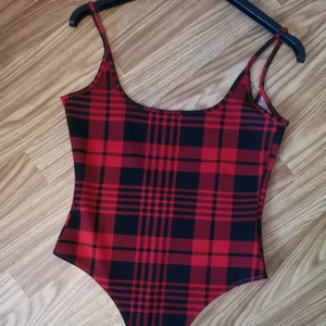 Body med öppen rygg - Snygg body med öppen rygg. Knäppning nedtill. Passar S-M