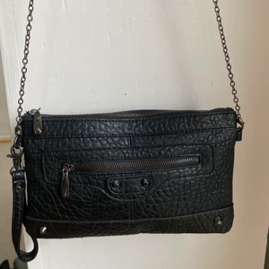Svart läderväska😍 - En svart läderväska med lite nitar på. Okänt märke. Kedjan är 120 cm lång och går ungefär till min höft när jag har på mig den (går att byta kedjan också om man skulle vilja). Hyfsat mycket utrymme och är som stockholmsstilen💕 27cmx17cm stor