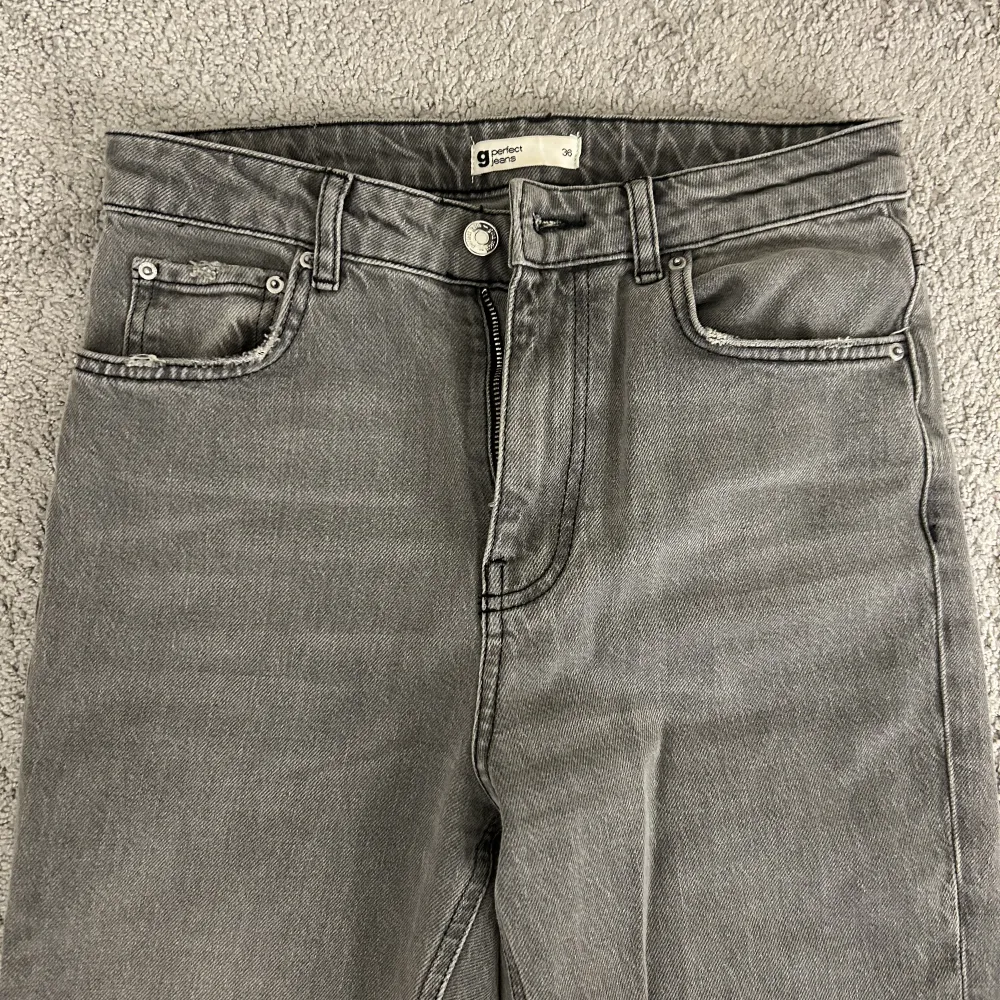 Gråa jeans med slit från Gina Tricot. Storlek 36, använda 1/2 gånger därav fint skick!. Jeans & Byxor.