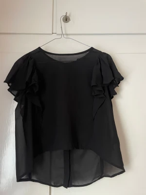 Blus - Svart blus med knappar. Korta ärmar. 